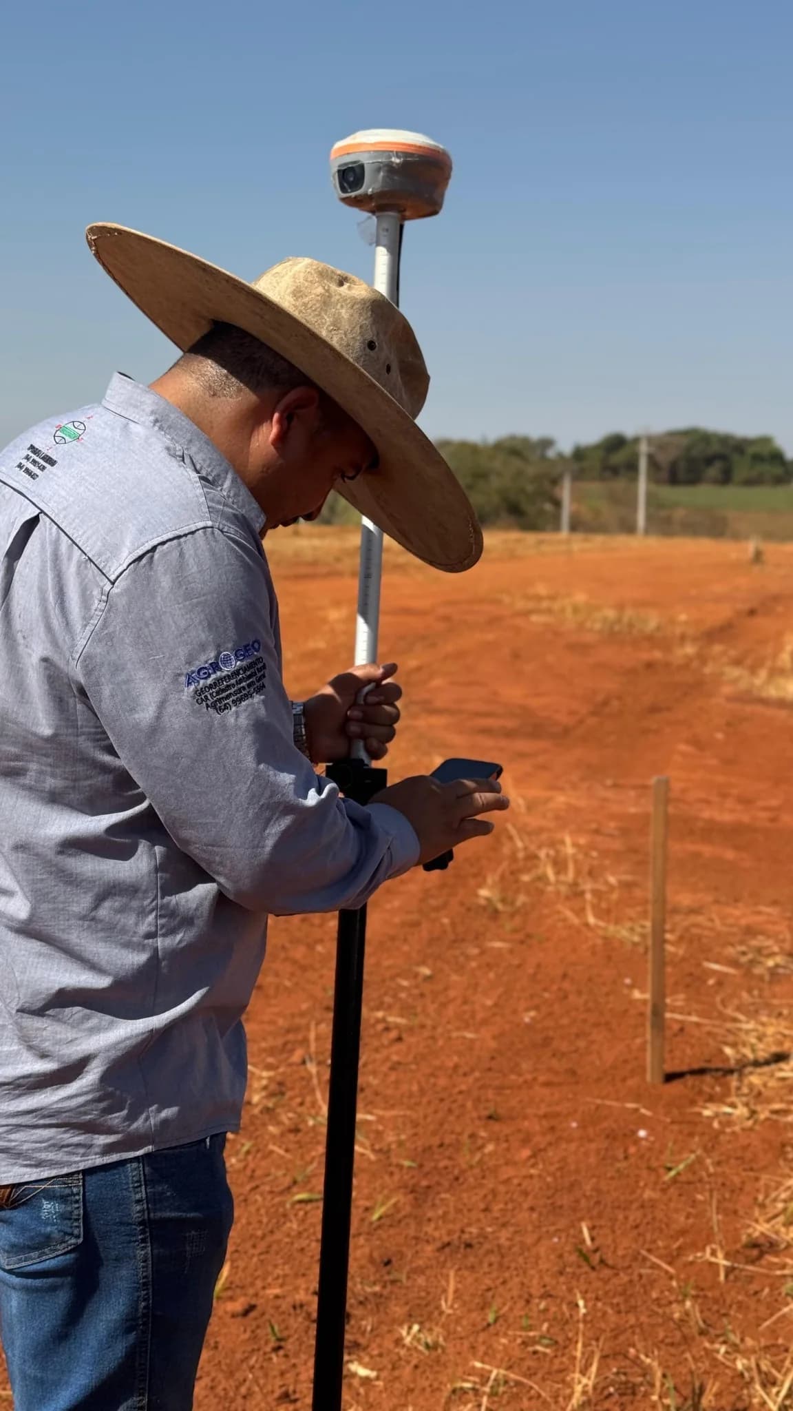 Profissional realizando levantamento topográfico em campo na UFV Itapaci